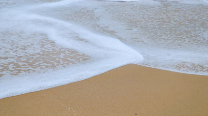 Close-up of sandy beach and ocean waves