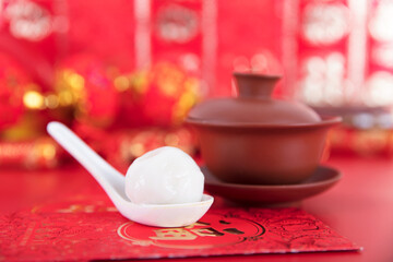 A cup of tea on a festive red background and a spoon with dumplings