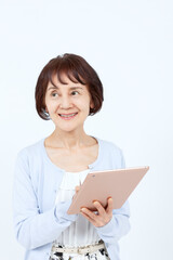 タブレットPCを持つシニア女性