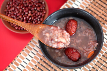 Overlooking a bowl of eight treasures porridge, porridge with wooden spoon and a plate of red beans - obrazy, fototapety, plakaty