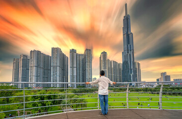  Tourist watching urban architecture sunset sky busy urban areas showing prosperous economic development in Ho Chi Minh City, Vietnam