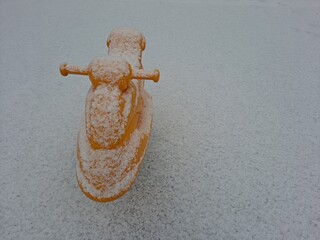 Snow covered yellow horse toy and ground