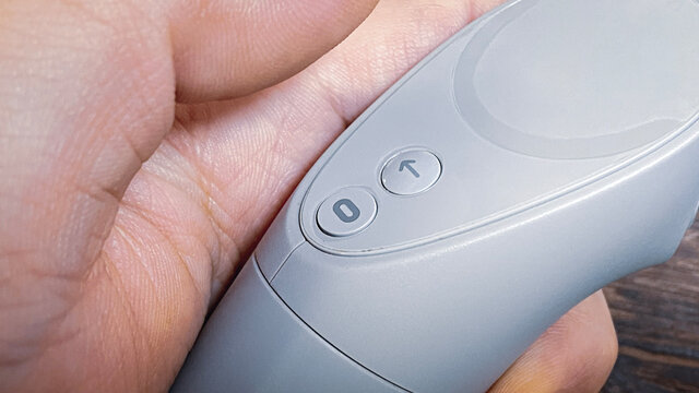 Oculus Go from Facebook。HMD/VRヘッドセット/VRゴーグルのコントローラーを持つ手。オキュラスロゴ。2021年1月撮影/日本