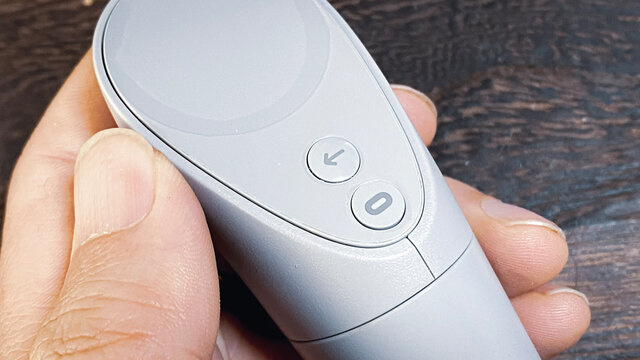 Oculus Go from Facebook。HMD/VRヘッドセット/VRゴーグルのコントローラーを持つ手。オキュラスロゴ。2021年1月撮影/日本