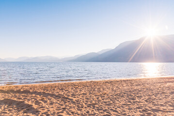 Skaha Lake and beach with blue sky and bright sunshine in autumn
