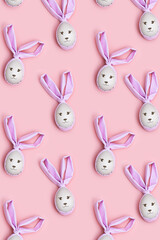 Easter eggs decorated cloth ears as cute bunny. Bright colors, spring holiday pattern on pink background.
