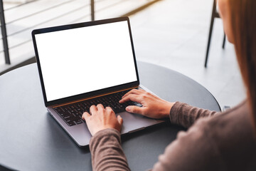 Mockup image of a woman using and typing on laptop computer with blank white desktop screen on the table