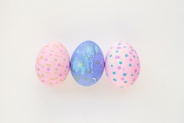Fototapeta na wymiar Set of colorful hand-painted Easter eggs. Bright children's drawings on Easter eggs top view on a white background. Happy Easter holiday and fun for children