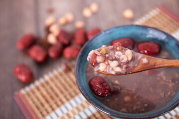 A bowl of eight treasures porridge and red dates scattered in the background