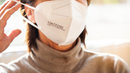 Corona Schutzmaske / FFP2 Atemschutzmaske / Frau / Maske aufsetzen / Freizeit / medizinische Maske 