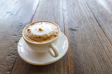 Black coffee latte art face bear image in white cup on wood table