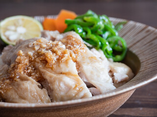 ご飯の上に乗せた鶏肉の料理、タレの付いたカオマンガイのクローズアップ。