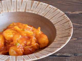 海老とネギがたくさん入った中華料理のエビチリのクローズアップ。