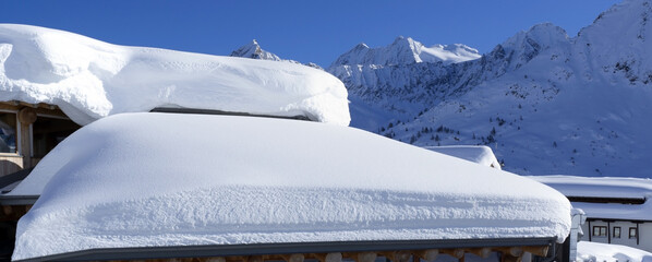 The roof of an house or hotel covered by massive quantity of fresh snow after heavy snowfall. Mountain and winter contest. Italian alps