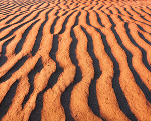 Harmonious lines of sand in the desert at sunset; bizarre wind patterns in the soft light of the setting sun