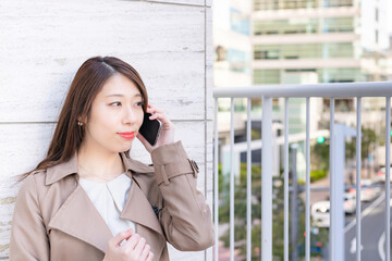 Fototapeta premium スマートフォンで通話中のビジネスウーマン
