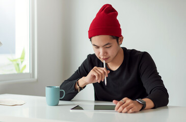 Asian man designer got creative in designing using tablet with coffee at the office.