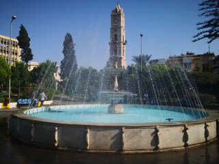 fountain in the park with ottoman clock tower 