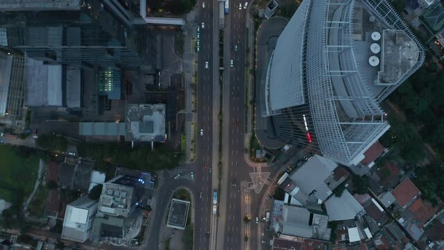Aerial Birds Eye Overhead Top Down View of busy city traffic and public transportation on a busy multi lane road at dusk
