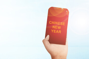 Human holding a red envelopes (Angpao) with Chinese New Year text