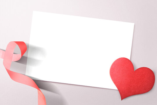 Empty white paper with heart and ribbon on a colored background