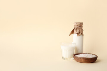 Bottle and glass of rice milk on color background
