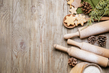 Fototapeta na wymiar Christmas tree branches, tasty cookies and rolling pins on wooden background