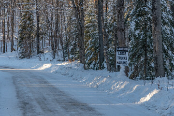 Caution Sign Large Trucks Hauling winter scene along a roadway