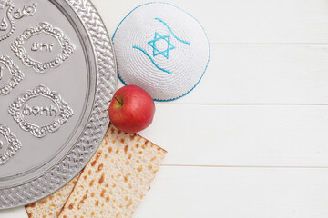 Passover Seder plate with matzo and Jewish cap on wooden background