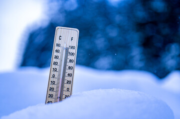 Winter time. Thermometer on snow shows low temperatures in celsius.