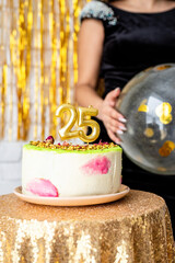 Golden candles 25 on birthday cake on golden glitter background