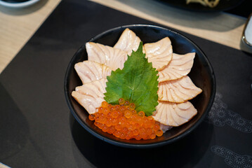 Salmon Ikura don. A bowl of Japanese rice topped with burnt sliced salmon and salmon roe.