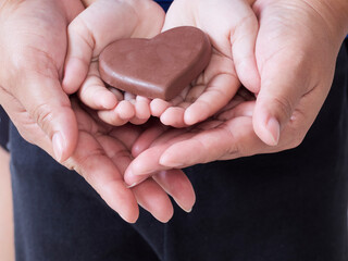 Woman and child holding chocolate heart