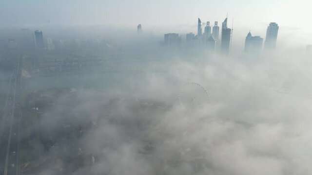 FOG IN UAE: Aerial view of Fog over Sharjah's Khalid Lake, Sharjah skyline covered in the winter morning fog, United Arab Emirates, 4K Drone Footage