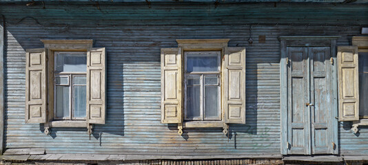 Windows with an open sun blinds  and door in broken rural home.