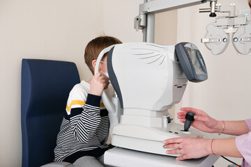 Checking the child's vision. Optometrist examines a patient s boy with special ophthalmic equipment in a modern clinic.