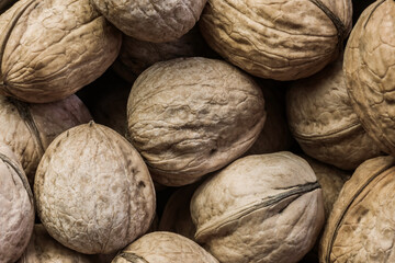 Food background with the texture of whole fruits walnuts in shell, healthy diet nutrition, a source of omega-3 fats proteins, vitamins E A and B, beneficial for the cardiovascular system