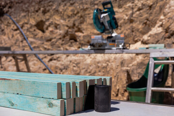 Timber and saw on construction site