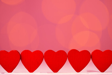 Red heart decoration against pink bokeh background