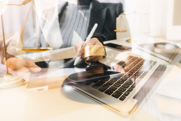 Business and lawyers discussing contract papers with brass scale on desk in office. Law, legal services, advice, justice and law concept picture with film grain effect