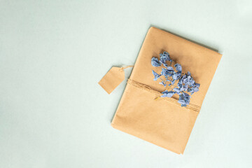 Gift box or present for Mother’s Day or Valentine’s Day.
Gift wrapped in craft paper tied with scourge and decorated with dried violet hydrangea flowers. Springtime. 8 March.