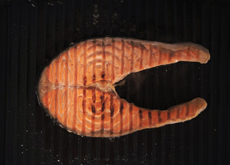 Salmon steak cooking on grill pan. Balanced diet concept