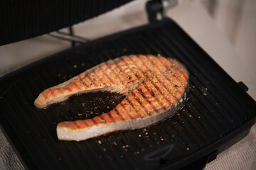 Salmon steak cooking on grill pan. Balanced diet concept