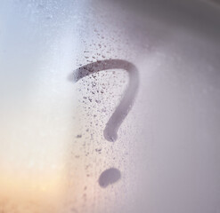 The question mark on the window with water drops on sunny background. Fogged window calligraphy
