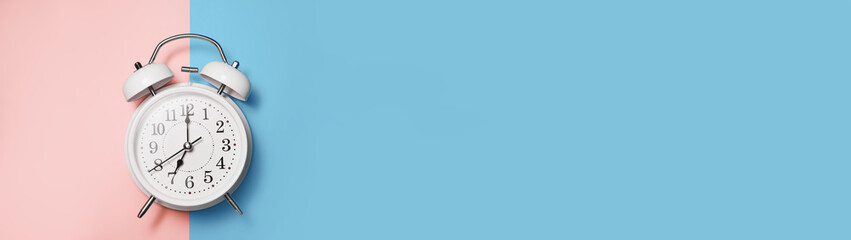 Clock alarm in vintage style on blue pink background with place for text banner