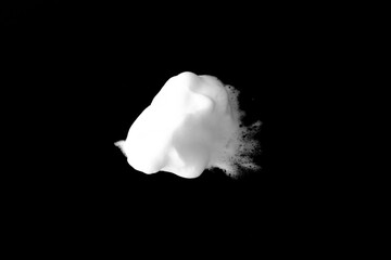 White soapy foam texture. Shampoo foam with bubbles.White facial foam creamy bubble soap sponge isolated on black background.