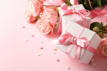 Roses and gift boxes on pink background, space for text