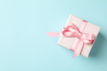 Gift box with pink ribbon on blue background