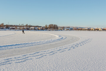 one person skating on a frozen lake