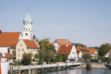 Ein Steg führt zur Stadt Wasserburg, dessen Bild geprägt durch den Zwiebelturm der St. Georg Kirche wurde, Wasserburg am Bodensee, Bayern, Deutschland